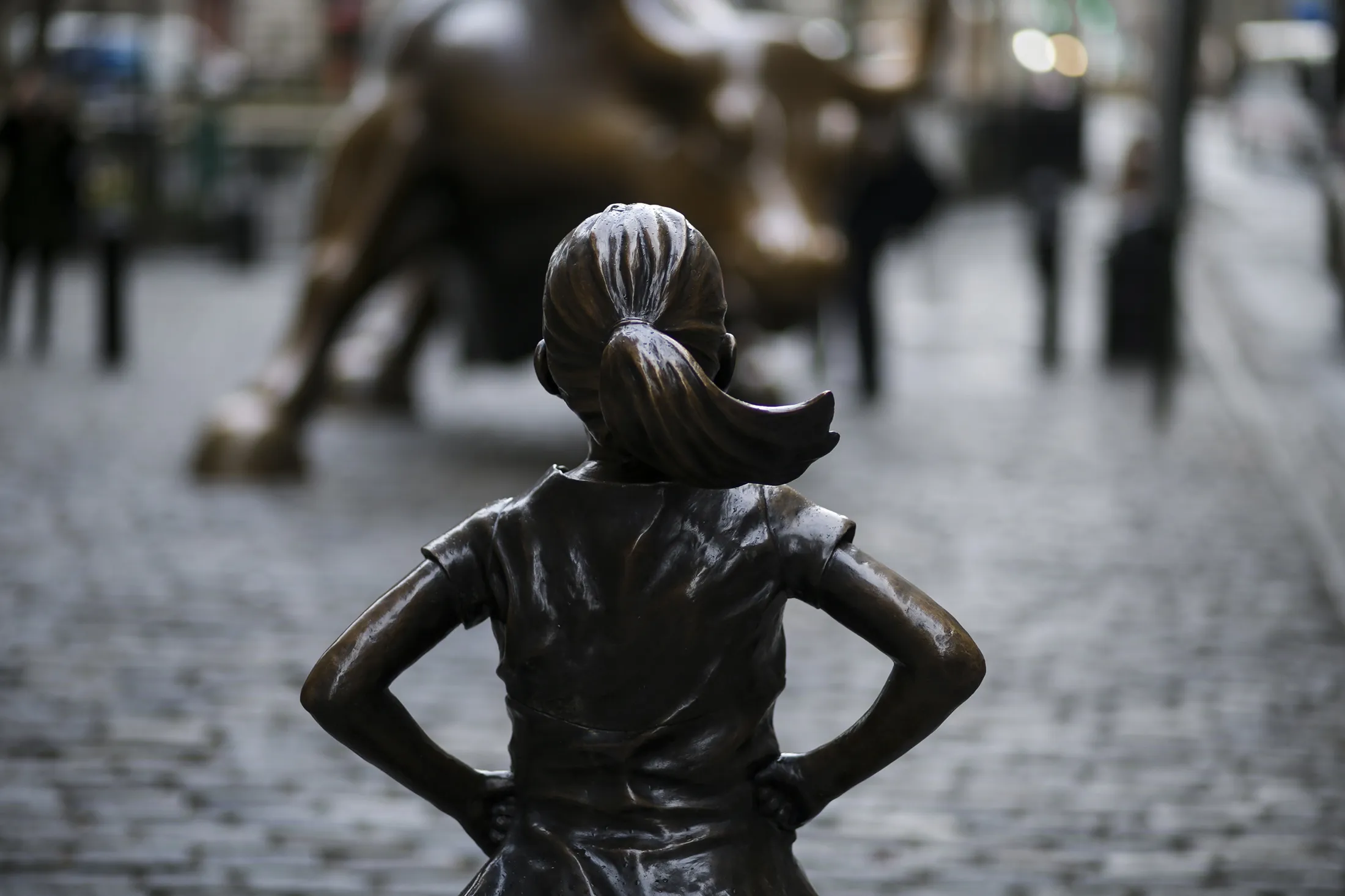 A statue of a defiant girl stands facing the Charging Bull sculpture in the Financial District of New York in 2017.