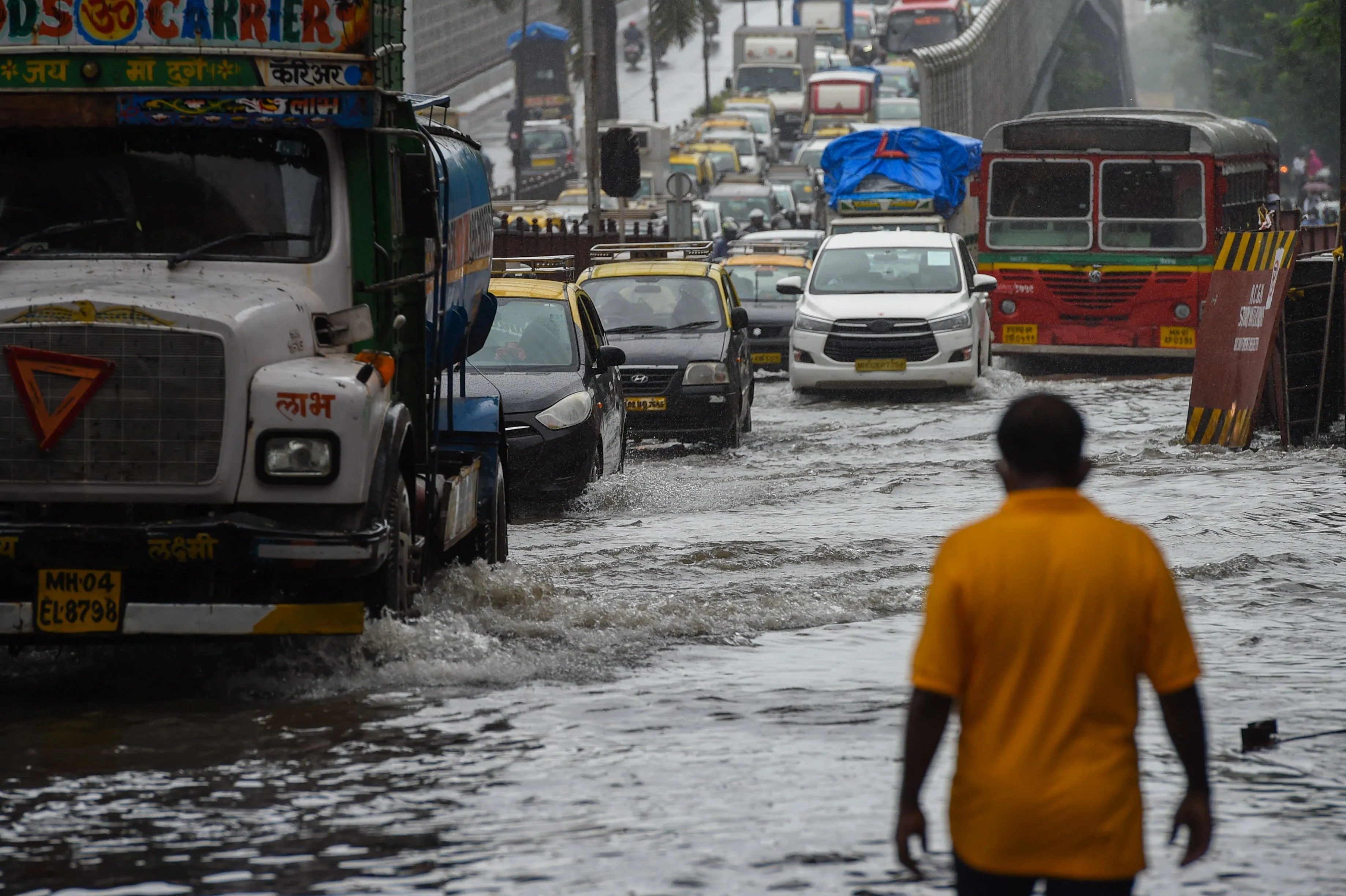 Vehicles drive through a waterlogged road after a heavy monsoon rainfall in Mumbai.