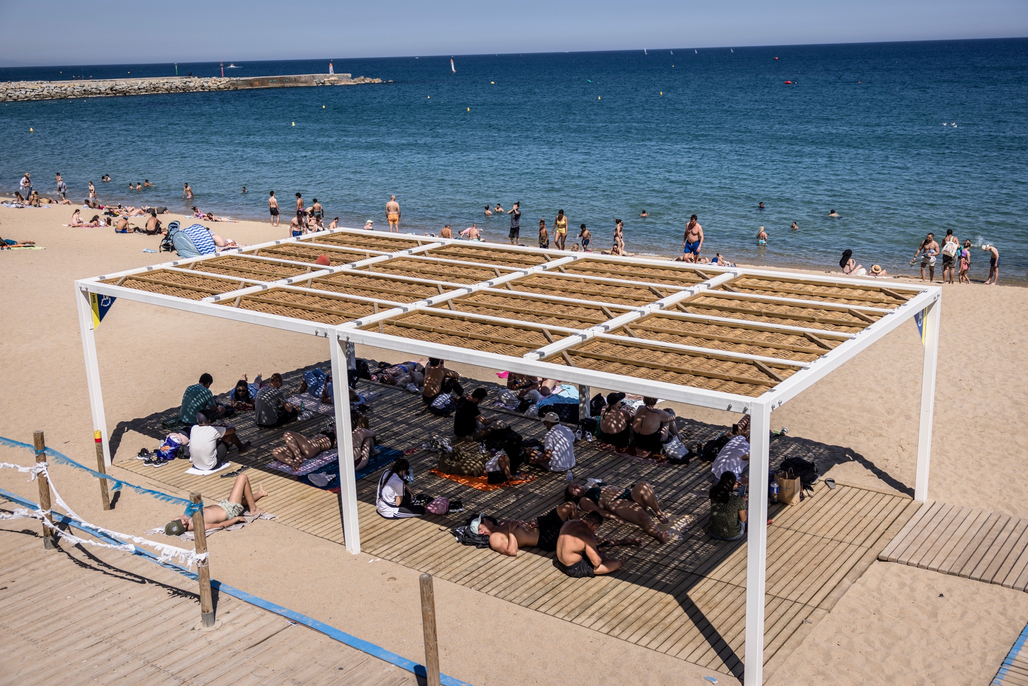 Tourists shelter from the sun during high temperatures in Barcelona, Spain, on Wednesday, May 27, 2026. The deadly heat wave gripping northwest Europe is set to intensify in Spain and France, lifting power demand for cooling and threatening fresh temperature records. Photographer: Angel Garcia/Bloomberg
