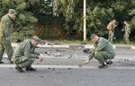 Investigators work on the site of explosion of a car driven by Darya Dugina outside Moscow.