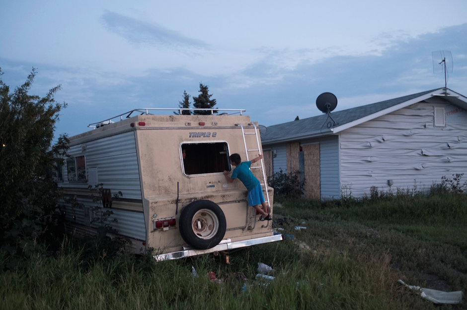 A boy plays on a broken-down RV on the Cote First Nation, near the town of Kamsack, Saskatchewan.