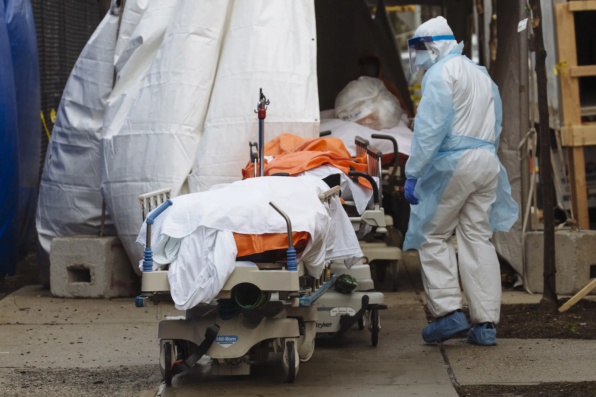 A medical worker&nbsp;walks past the bodies of deceased patients from a refrigerated overflow morgue in Brooklyn, New York on April 3.