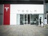 Pedestrians walk past a Tesla Inc. showroom in Beijing.
