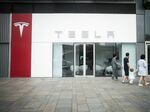Pedestrians walk past a Tesla Inc. showroom in Beijing.