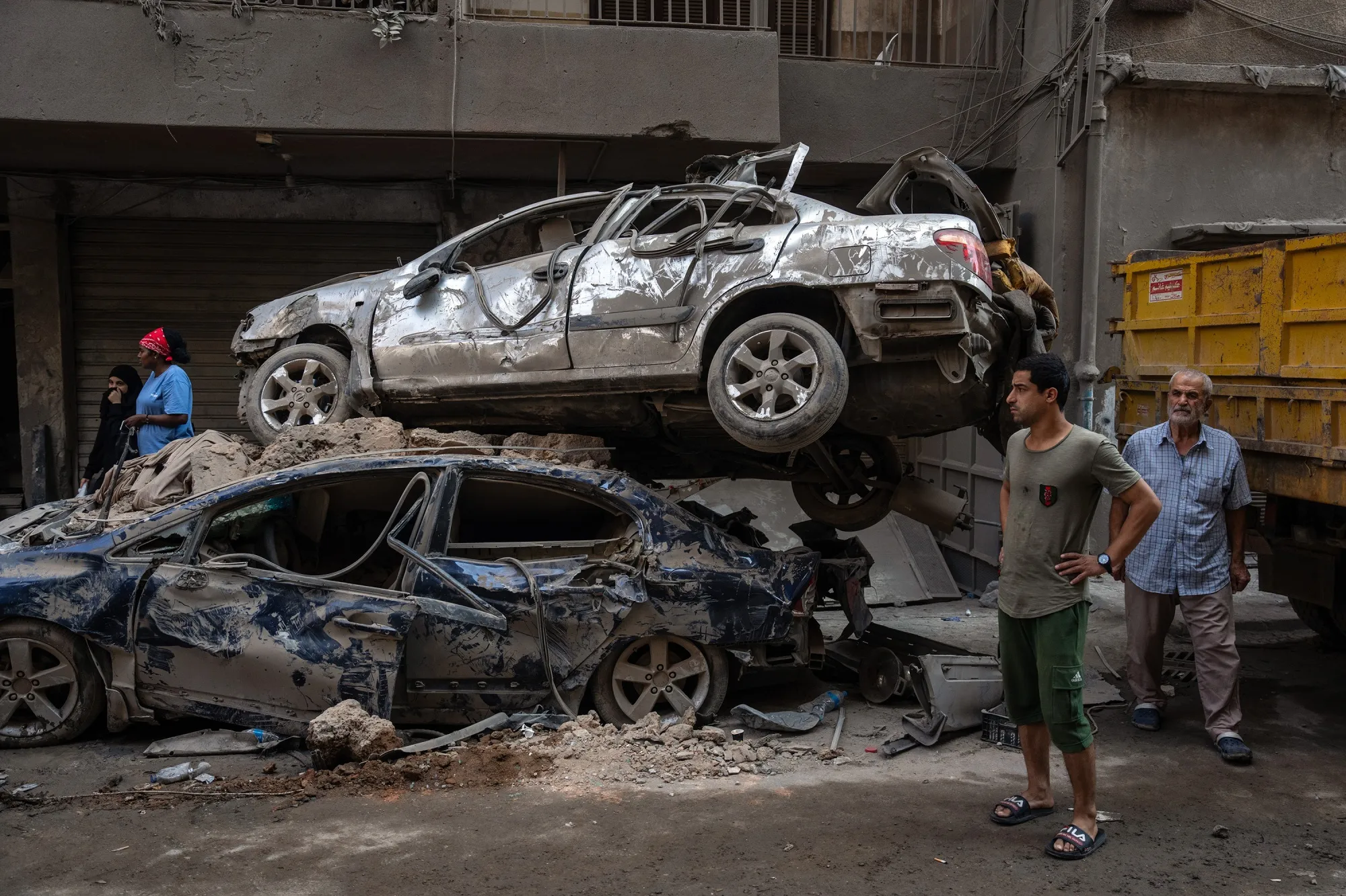 People stand next to ruined cars following an Israeli airstrike&nbsp;in Beirut, Lebanon,&nbsp;on October 11.