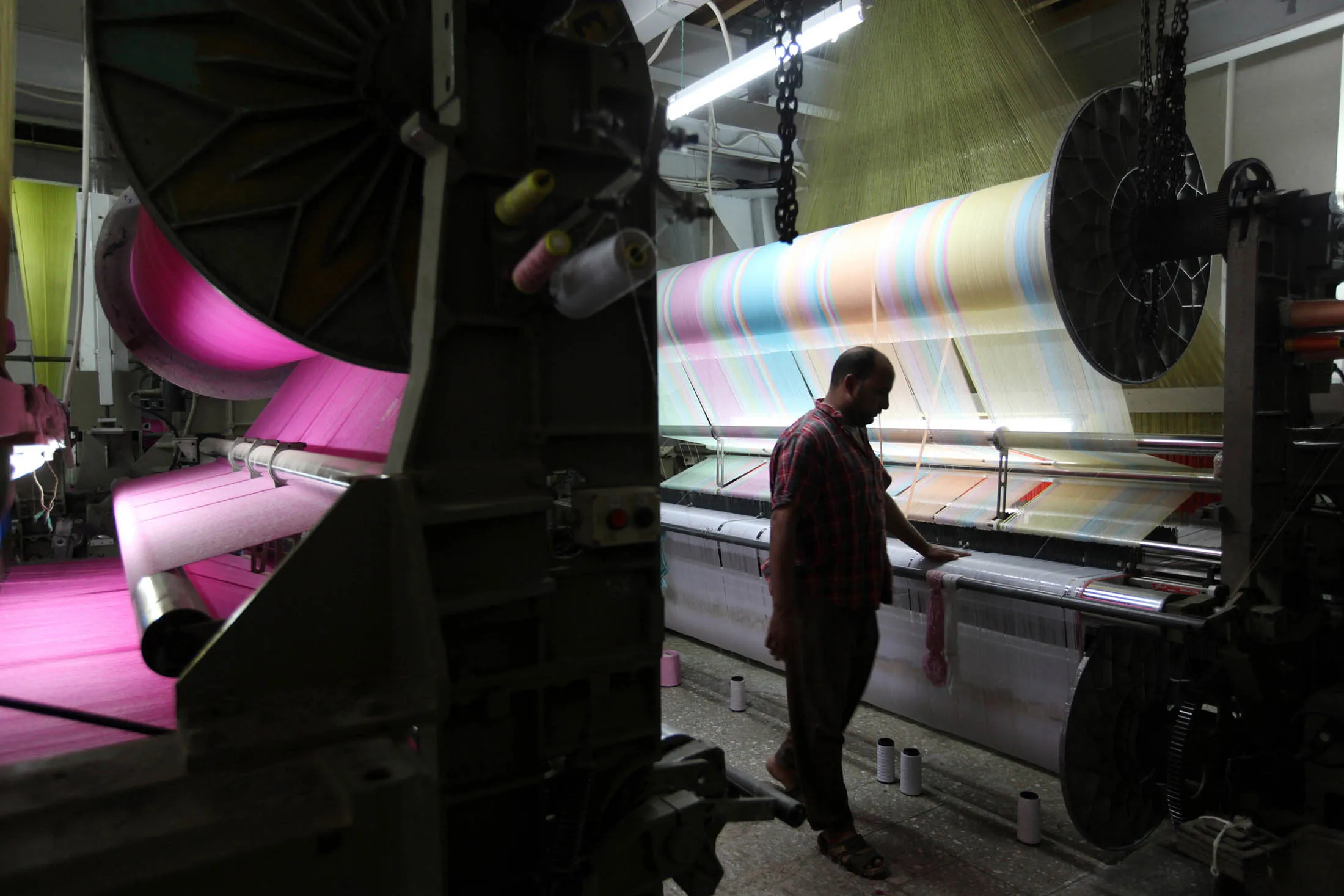 An employee monitors cotton being processed on a machine in a cotton factory in Mahalla, Egypt. The highest-quality Egyptian material costs twice as much as the standard grade sourced from India.
