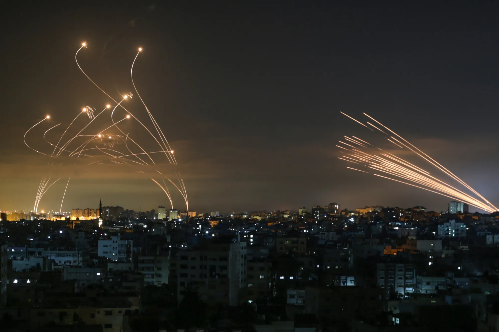 The Israeli Iron Dome missile defence system, left, intercepts rockets fired by Hamas in May 2021.
