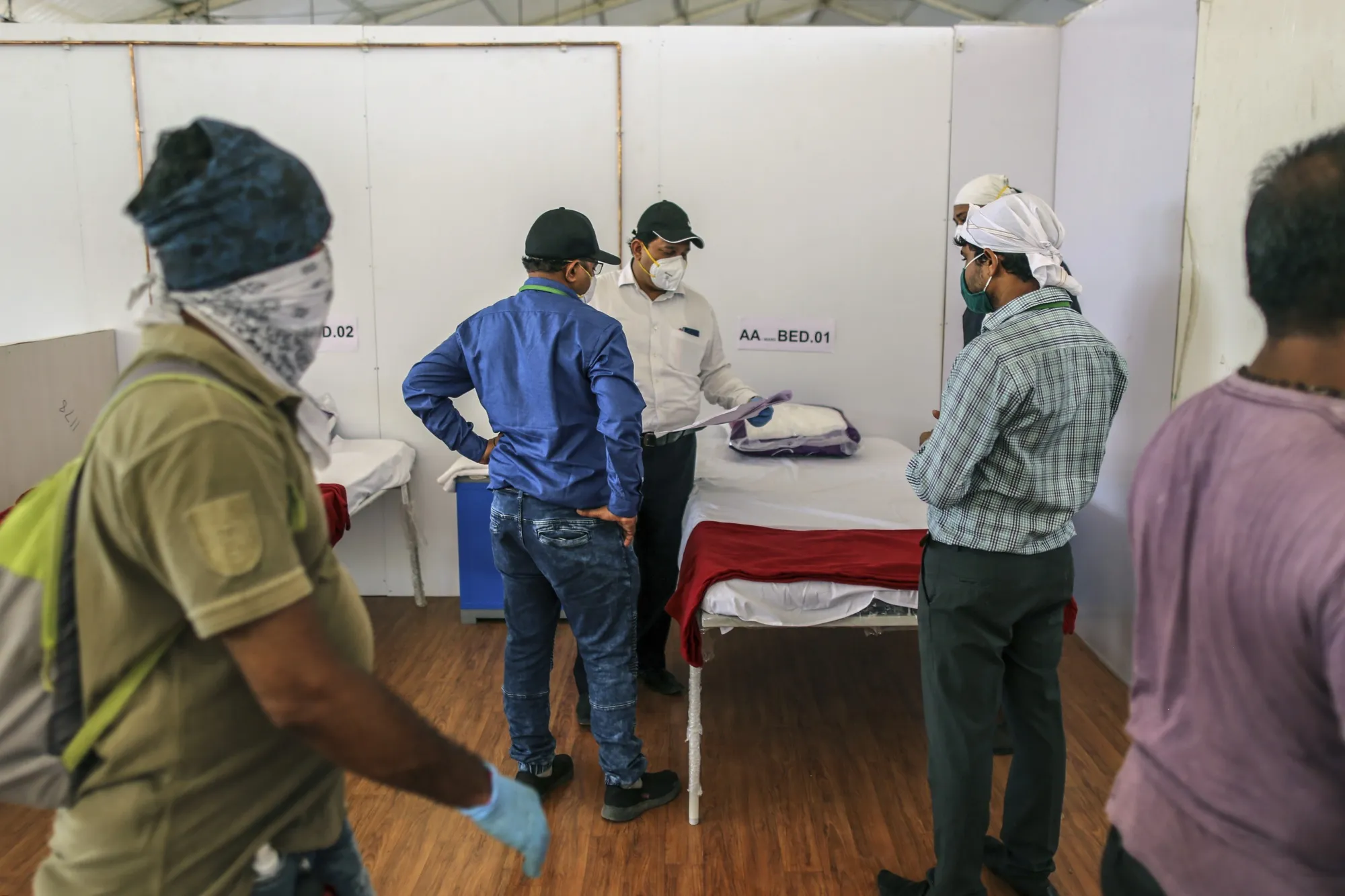 Officials and workers check a plan as the finishing touches are applied to a ward at a Covid health center&nbsp;in Mumbai, India, on May 16.