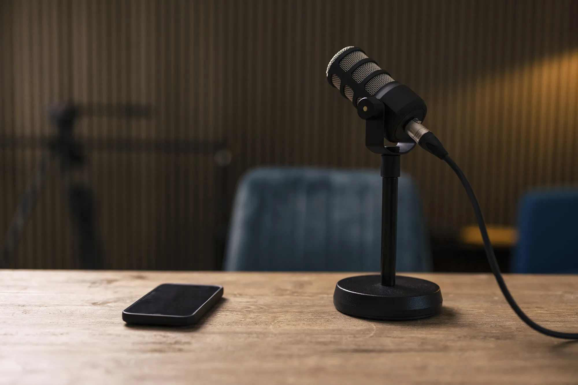 Smart phone by microphone on desk in recording studio