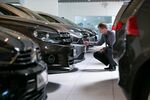 An employee inspects a Volkswagen automobile at a Volkswagen AG showroom in Berlin, Germany.