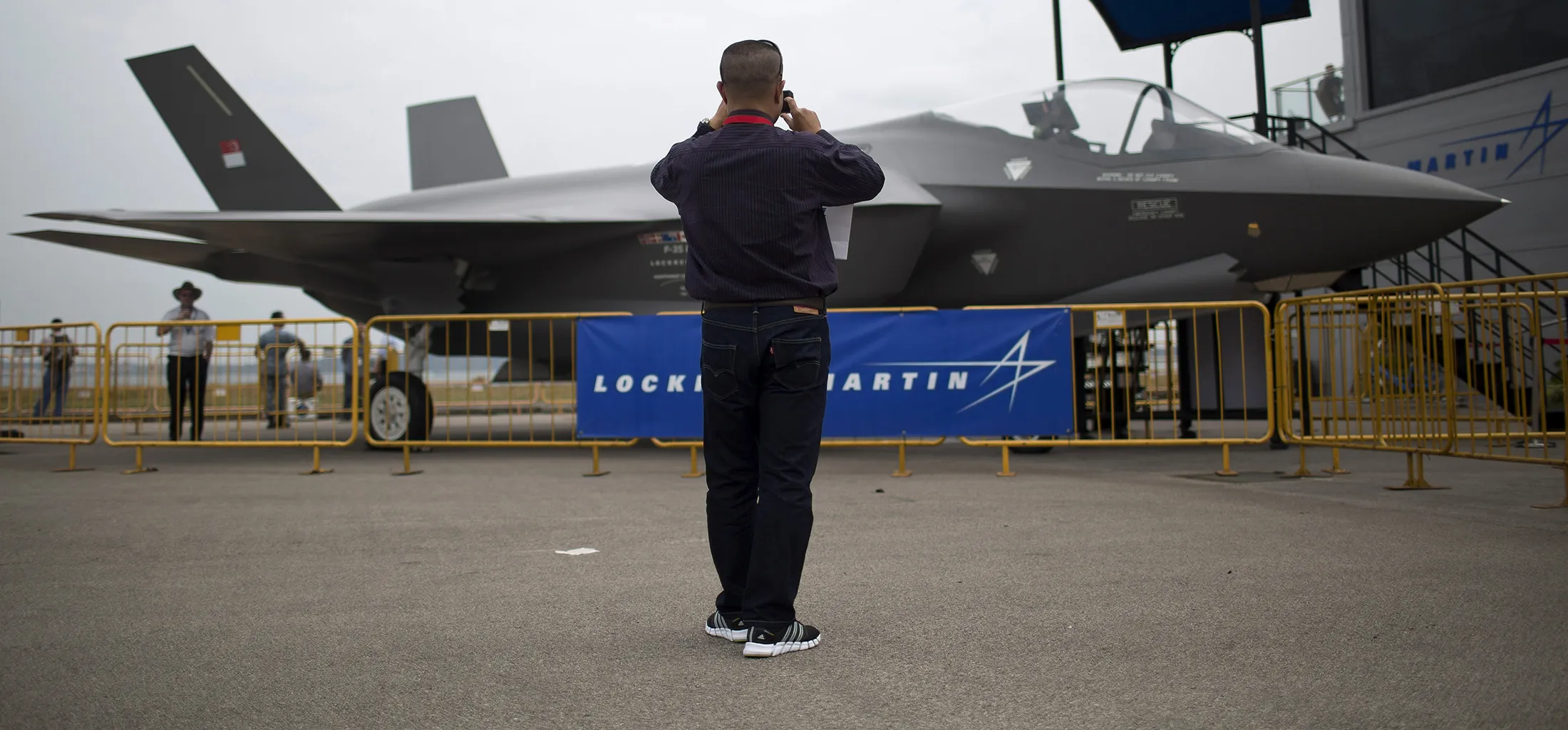 A man takes a photograph of a Lockheed Martin Corp. F-35 Lightning II fighter jet at the Singapore Airshow.

