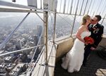 A newly married couple kiss on the Empire State Building after their Valentine's Day wedding in New York City, where there are 200,000 more single women than men.