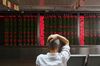 A man checks stock price movements at a securities company in Beijing on July 4, 2018. - Simmering trade tensions between the world's top two economies are set to erupt into a full-blown trade war on July 6, with Washington poised to impose new tariffs on 34 billion USD in Chinese goods. (Photo by GREG BAKER / AFP) (Photo credit should read GREG BAKER/AFP/Getty Images)