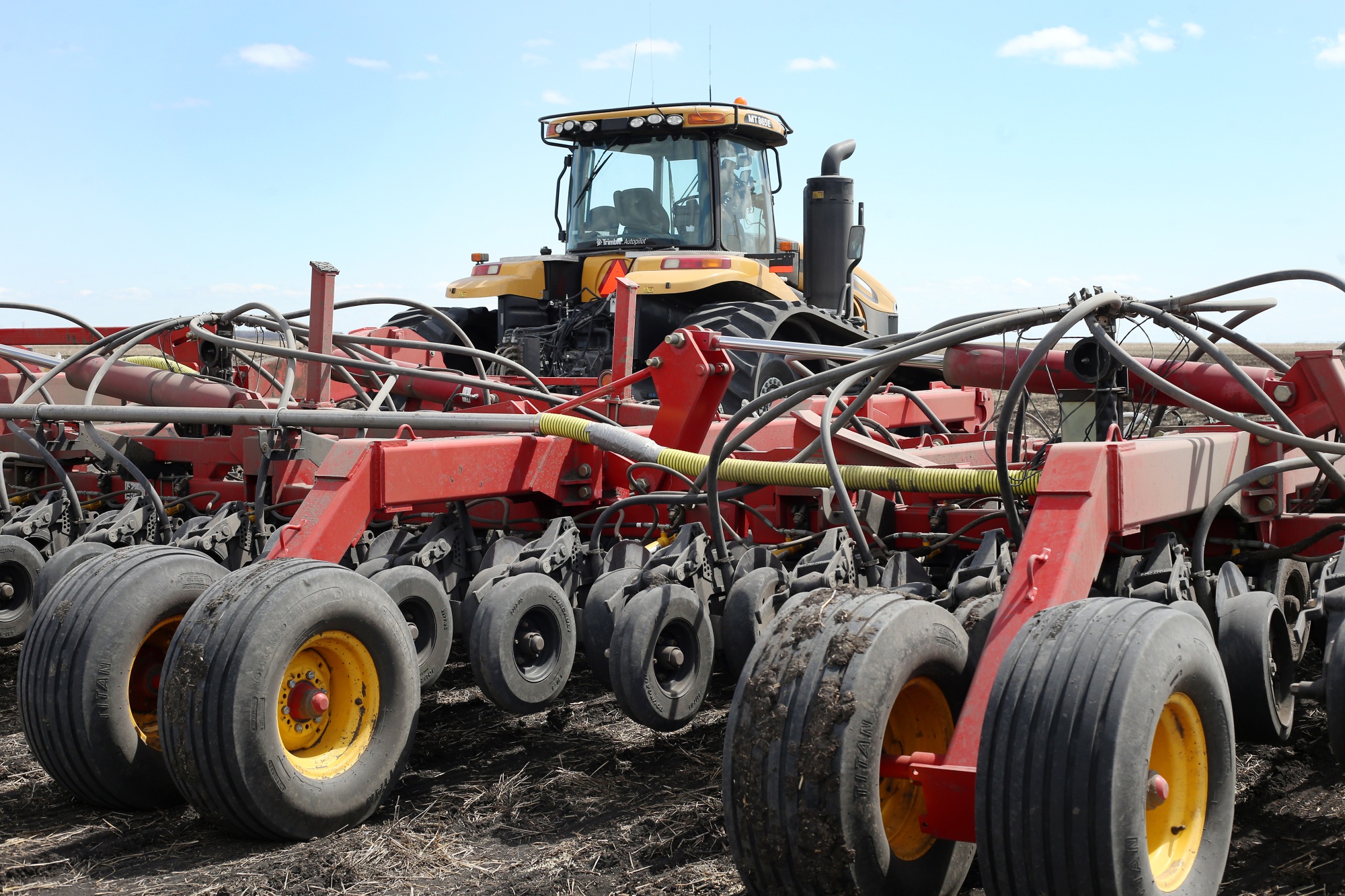 An AGCO Corp. Challenger tractor pulls an&nbsp;air seeder while planting canola seeds.