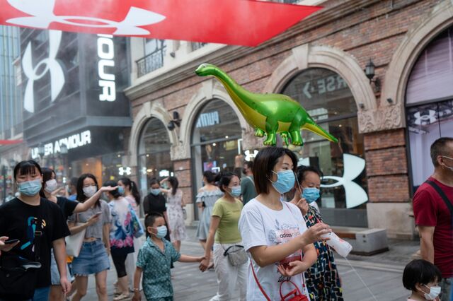 Shoppers stroll in a pedestrian mall that would have been deserted during the lockdown in Wuhan.