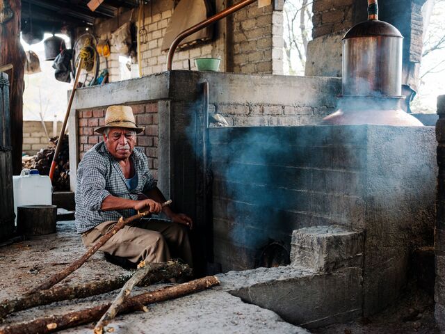 Man lighting the oven used to distill his mezcal brand, Todos Santos Mezcaleros.