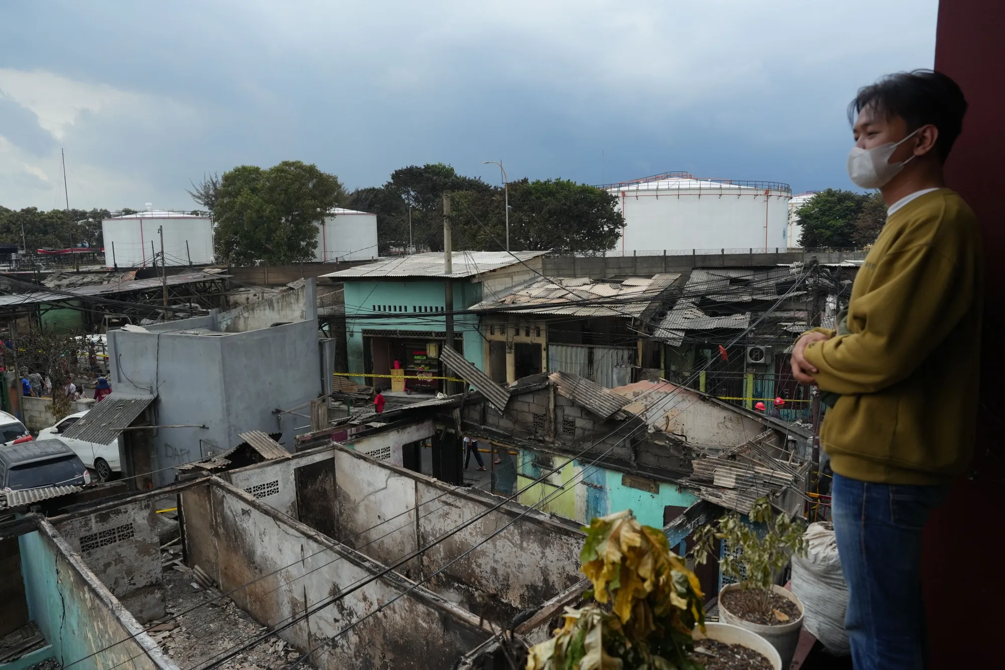 A resident surveys burnt homes following a fire near a Pertamina facility in Jakarta on March 4.