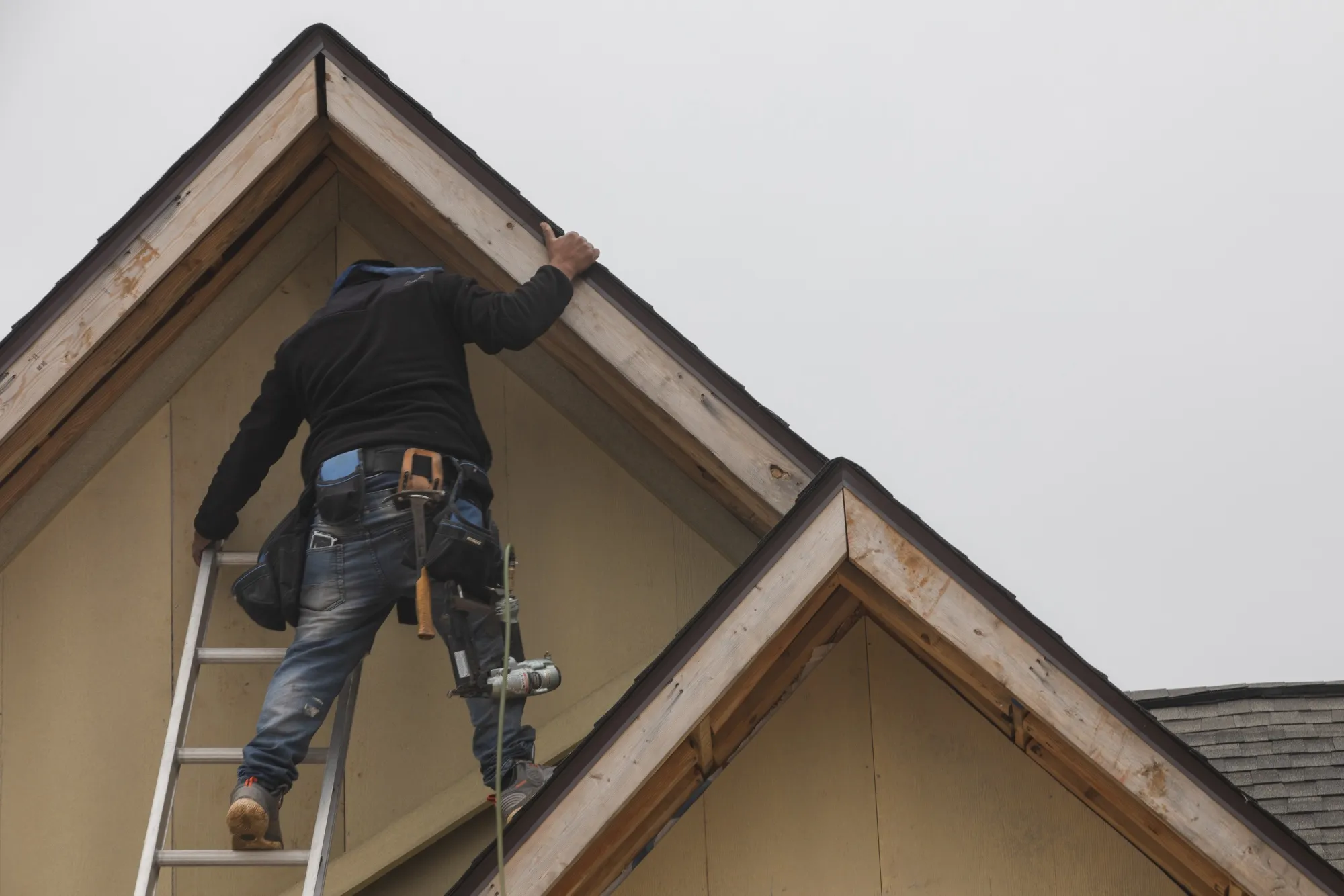A construction worker applies trim to the roof of a new home in Foley, Alabama, US.