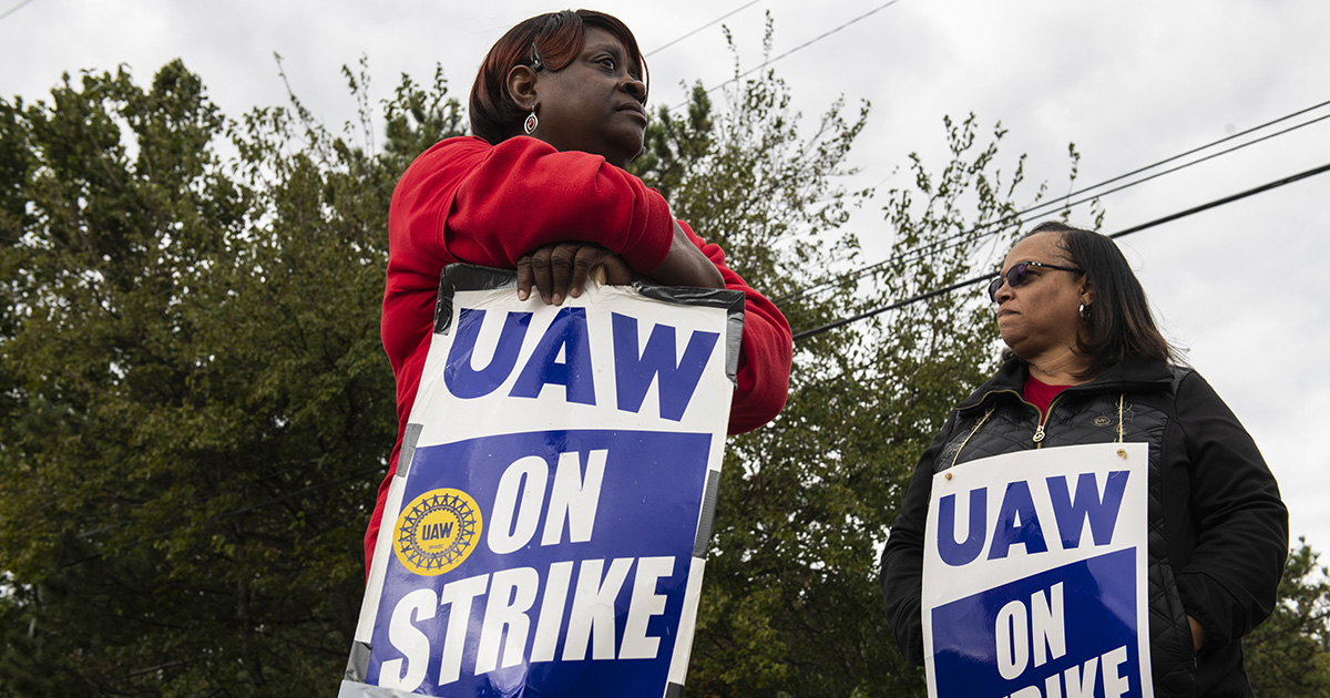 Demonstrators hold signs during a United Auto Workers (UAW) strike outside the General Motors Co. (GM) plant in Romulus, Michigan&nbsp;on&nbsp;Oct. 4.
