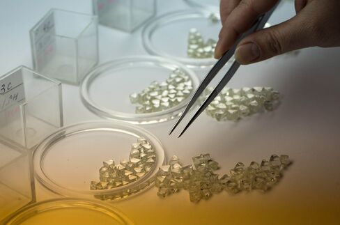 A worker selects rough cut diamonds during the grading process.