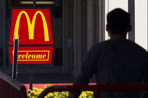 A Pedestrian Walks Past McDonald's Corp. Signage