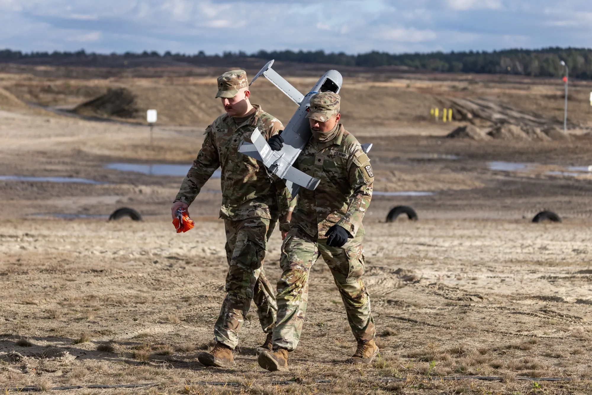 US soldiers carry a Merops interceptor&nbsp;drone during tests at the Nowa Deba military training ground in south-eastern Poland, on Nov. 18, 2025.