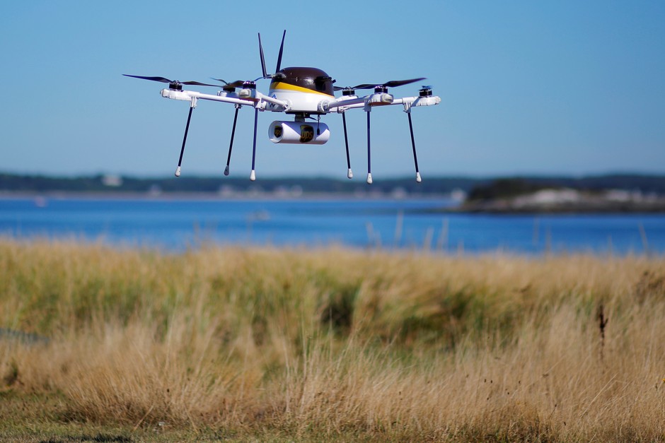 A drone carries a UPS package during a company demonstration of drone delivery in Massachusetts.