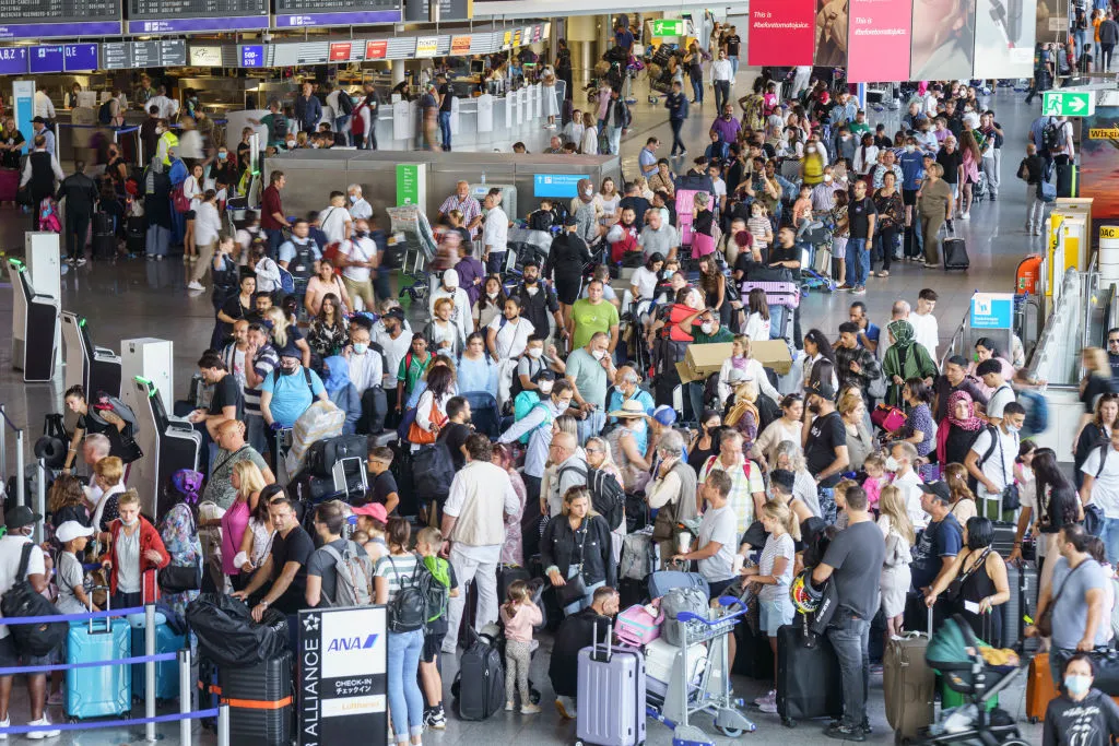 A crowd lines up in the departure area of Frankfurt Airport.