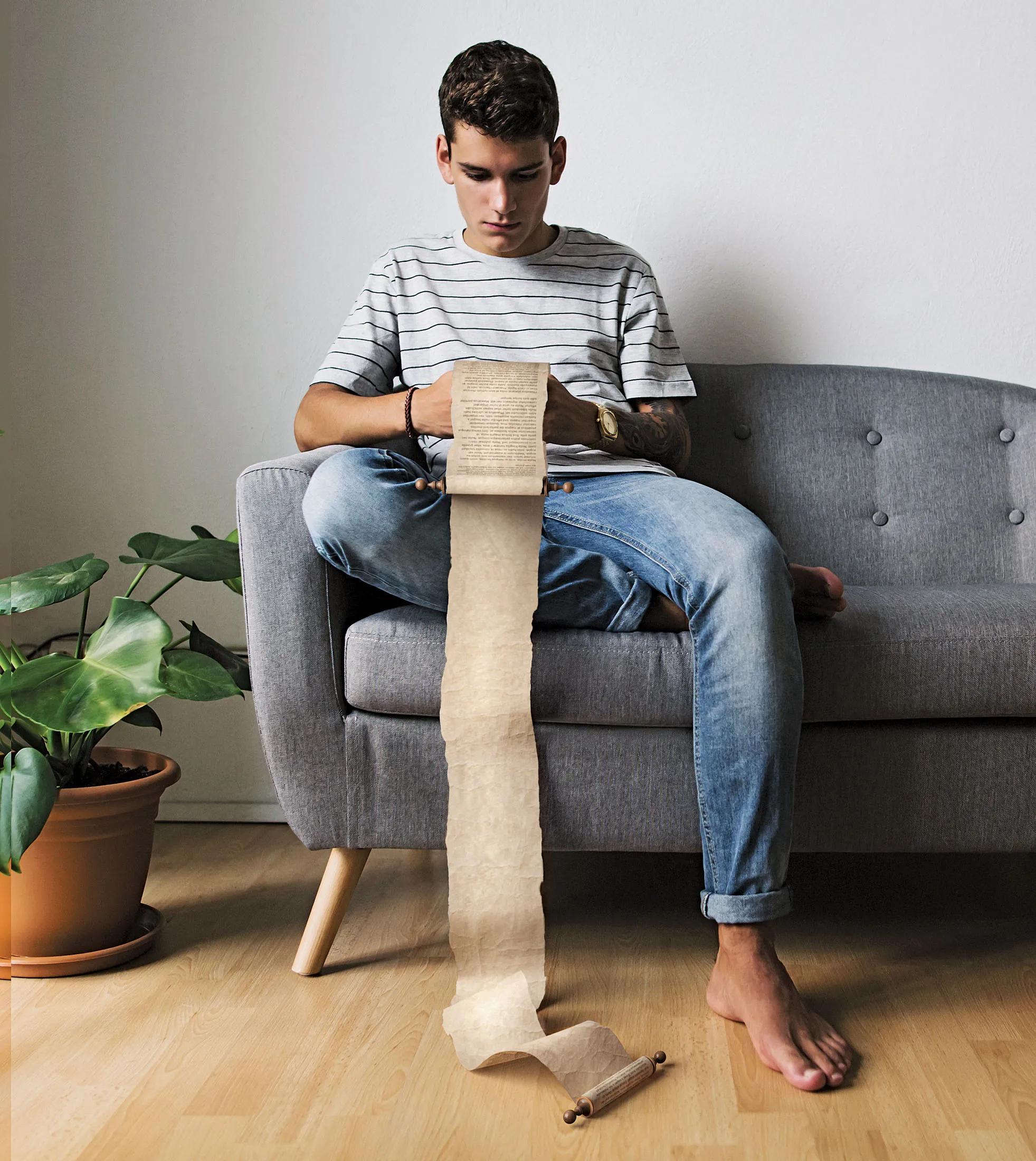 Teenage boy sitting on couch at home looking at cell phone