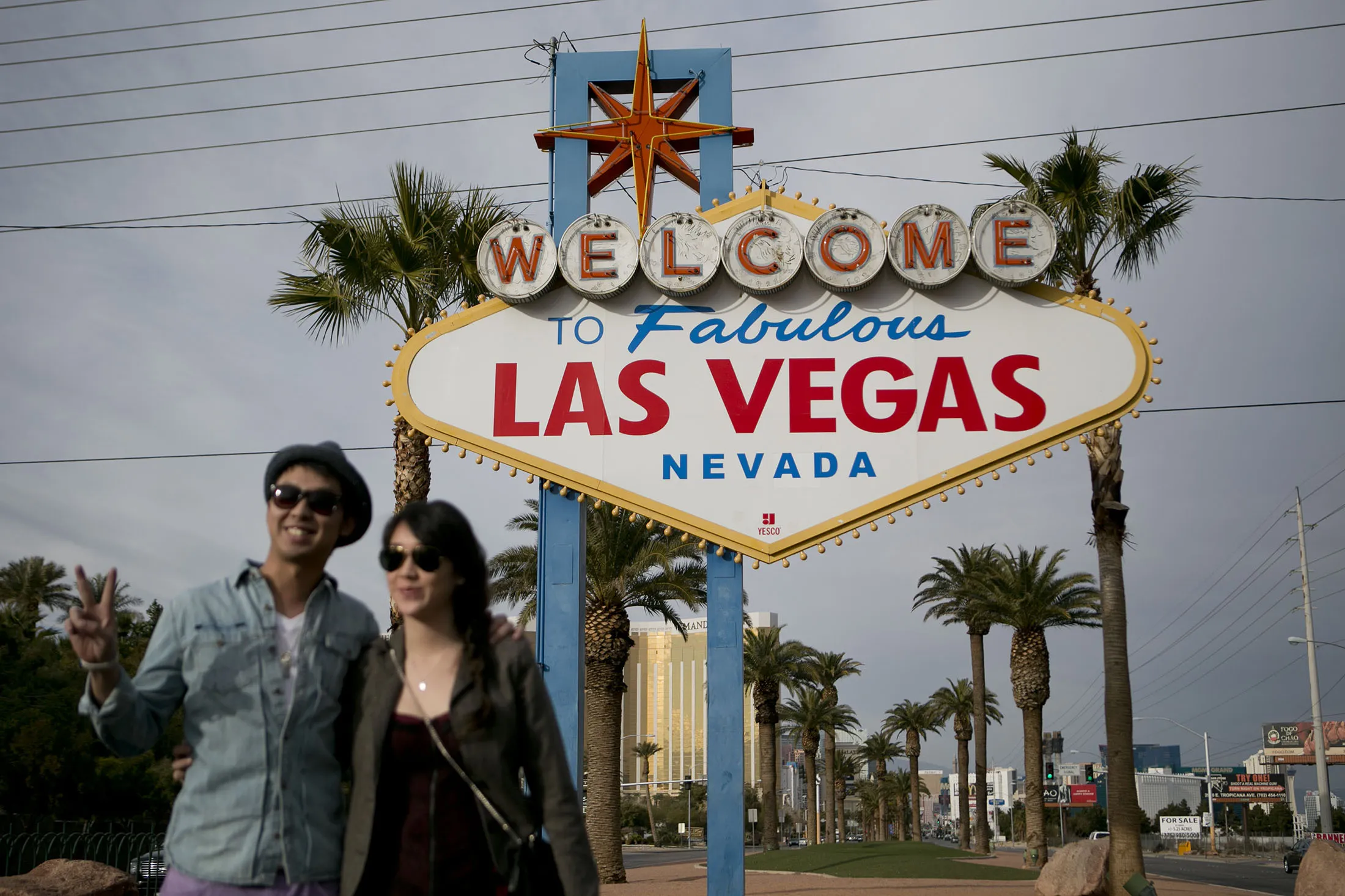 Visitors pose in front of the "Welcome to Fabulous Las Vegas" sign along the Strip in Las Vegas, Nevada, U.S. The Nevada Transportation Authority granted permits to the ride-hailing mobile applications to operate in the state.
