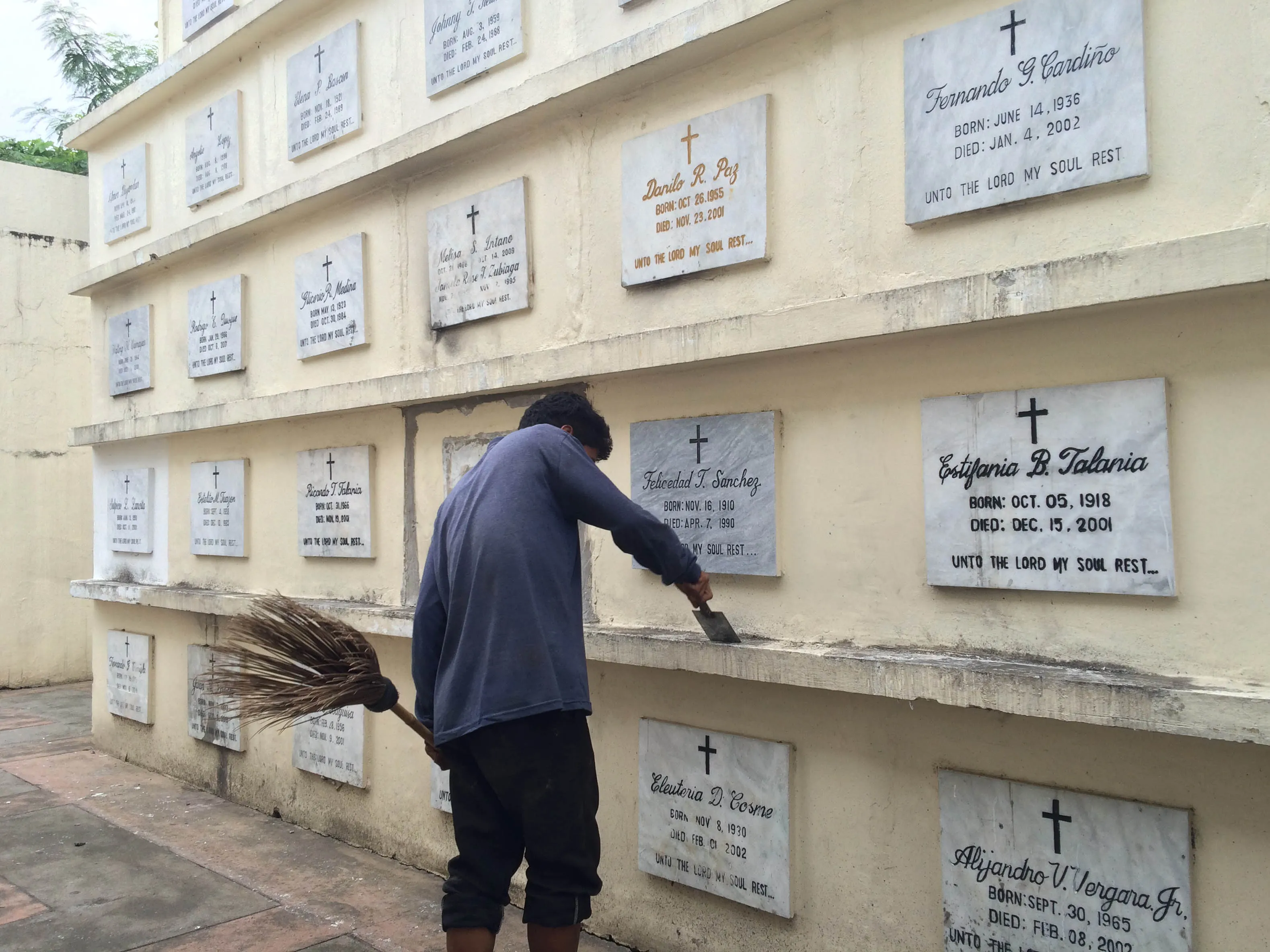 GOLDEN HAVEN, LAS PINAS, NCR, PHILIPPINES - 2015/10/18: Men cleaning up the tombs and grave of their departed loved ones in time of All Saint's Day and All Soul's Day where thousand of Filipinos will visit the different cemetery around the Philippines.
