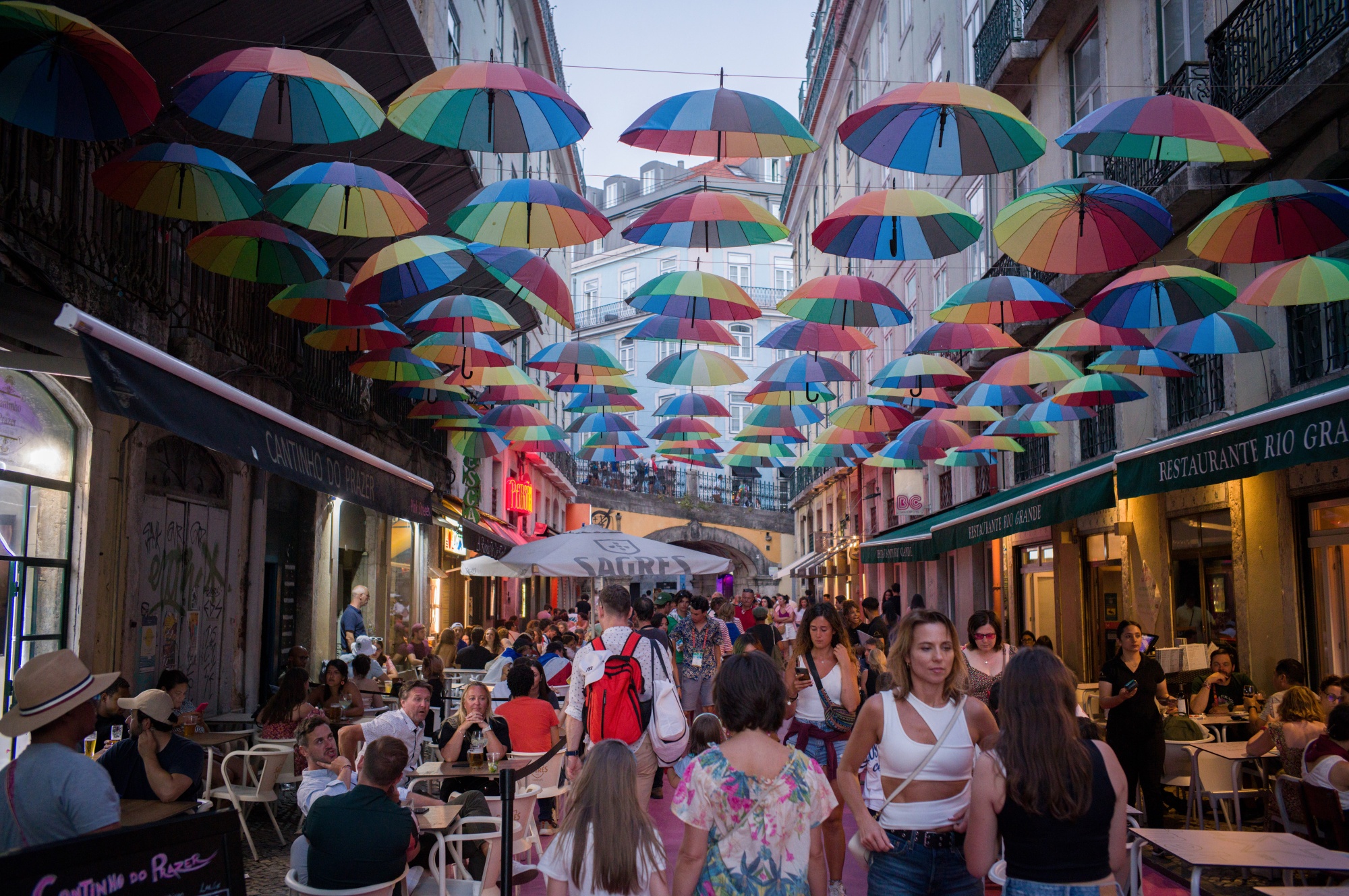 Tourists pass diners on Pink Street in the Cais do Sodre district of Lisbon, Portugal.