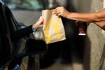 A worker passes a bag of food to a customer at the drive-thru window at a McDonald's fast food restaurant in White House, Tennessee, U.S., on Wednesday, Jan. 18, 2017. McDonald's shares fell as much as 2 percent to $119.82 on Monday after the results were posted.
