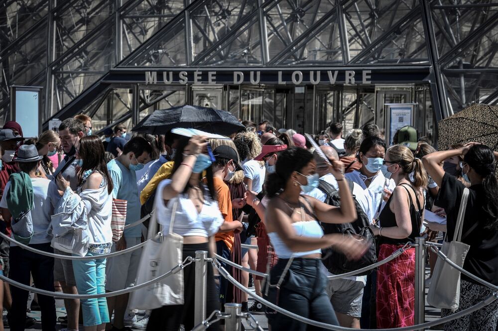 People wearing a protective face masks queue at the entrance of the Louvre in Paris on Aug. 6.