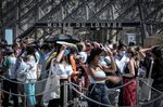 People wearing a protective face masks queue at the entrance of the Louvre in Paris on Aug. 6.