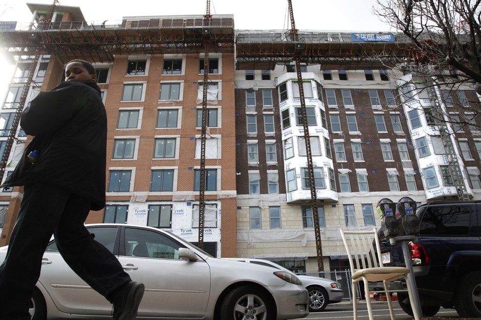A young man walks past a corridor with new development in Washington D.C., where rents are definitely too damn high.