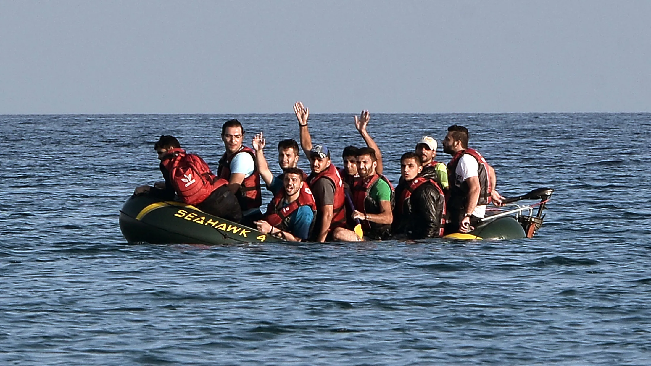 Syrian migrants call for help from their half-sunk small dinghy as they arrive to the shores of the Greek island of Kos, on August 17, 2015.
