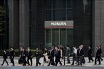 Pedestrians walk past a branch of Nomura Securities Co., a unit of Nomura Holdings Inc., in Tokyo.