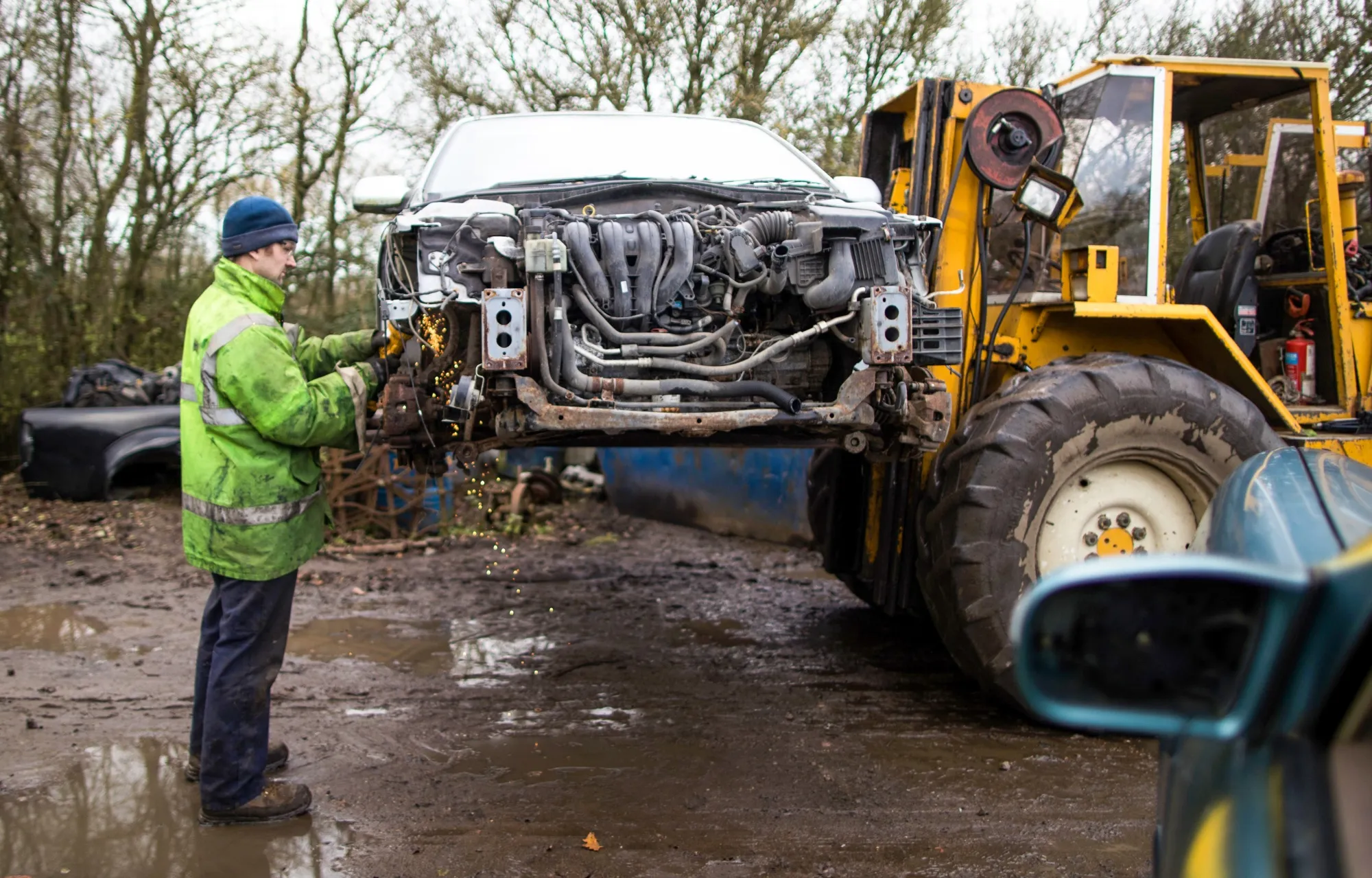 An employee uses an angle grinder at a scrap automobile and recycling yard in Ditchingham, U.K.