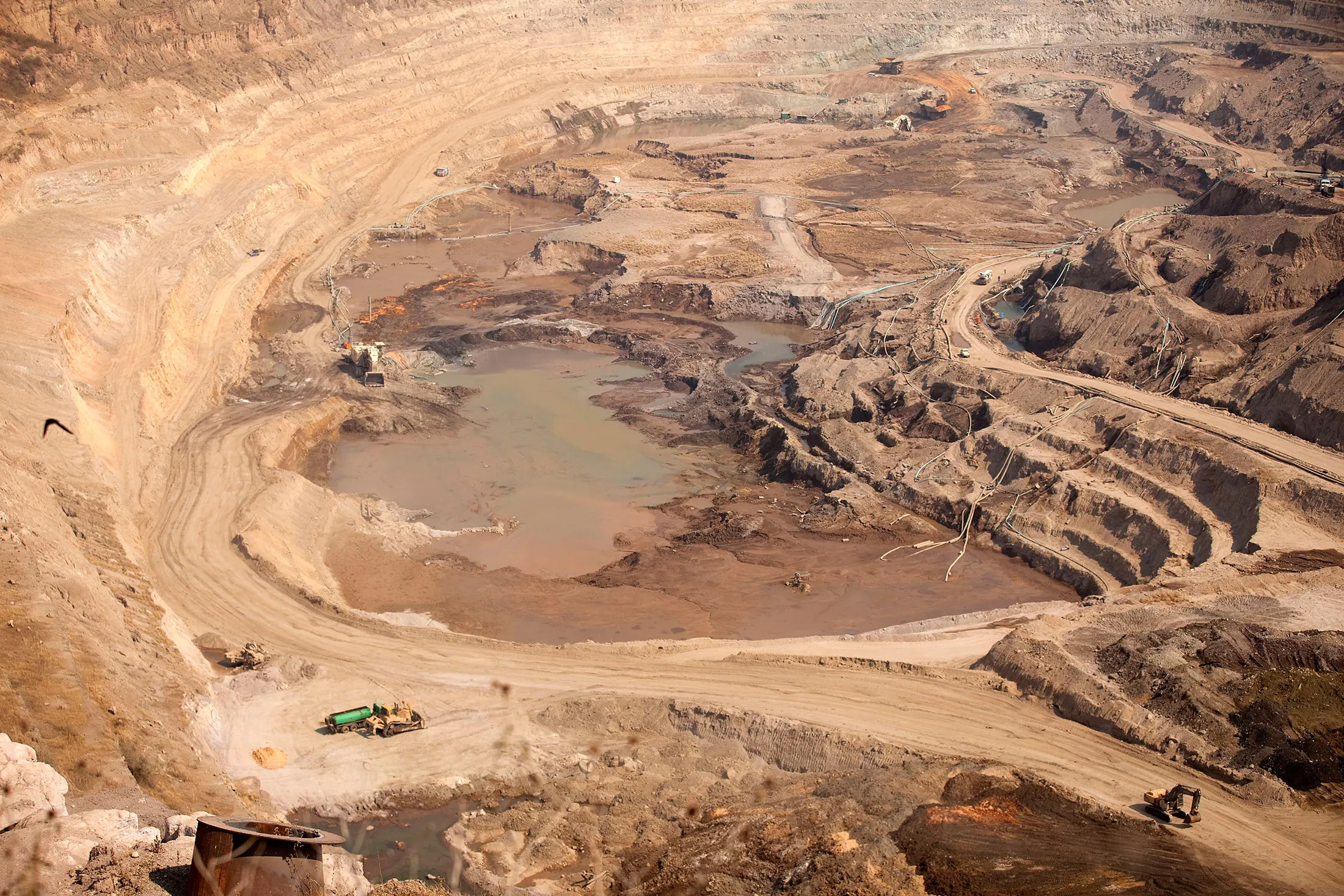 Workers operate mining excavators to dig oxide ore from the open pit at Katanga Mining Ltd.'s KOV copper-cobalt mine, part-operated by the Kamoto Copper Co., in Kolwezi, Katanga province, Democratic Republic of Congo, on Wednesday, Aug. 1, 2012. XXX.
