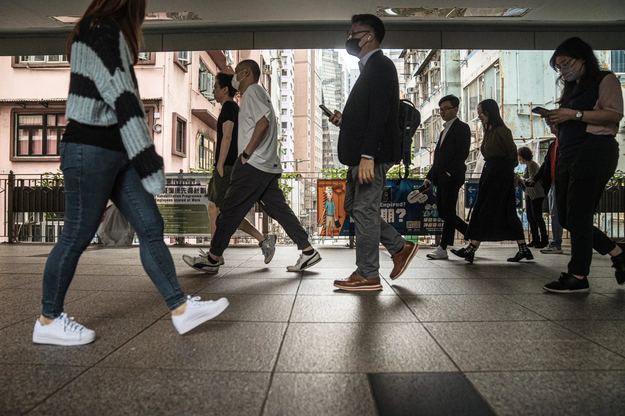 Pedestrians on a footbridge in Hong Kong, China.