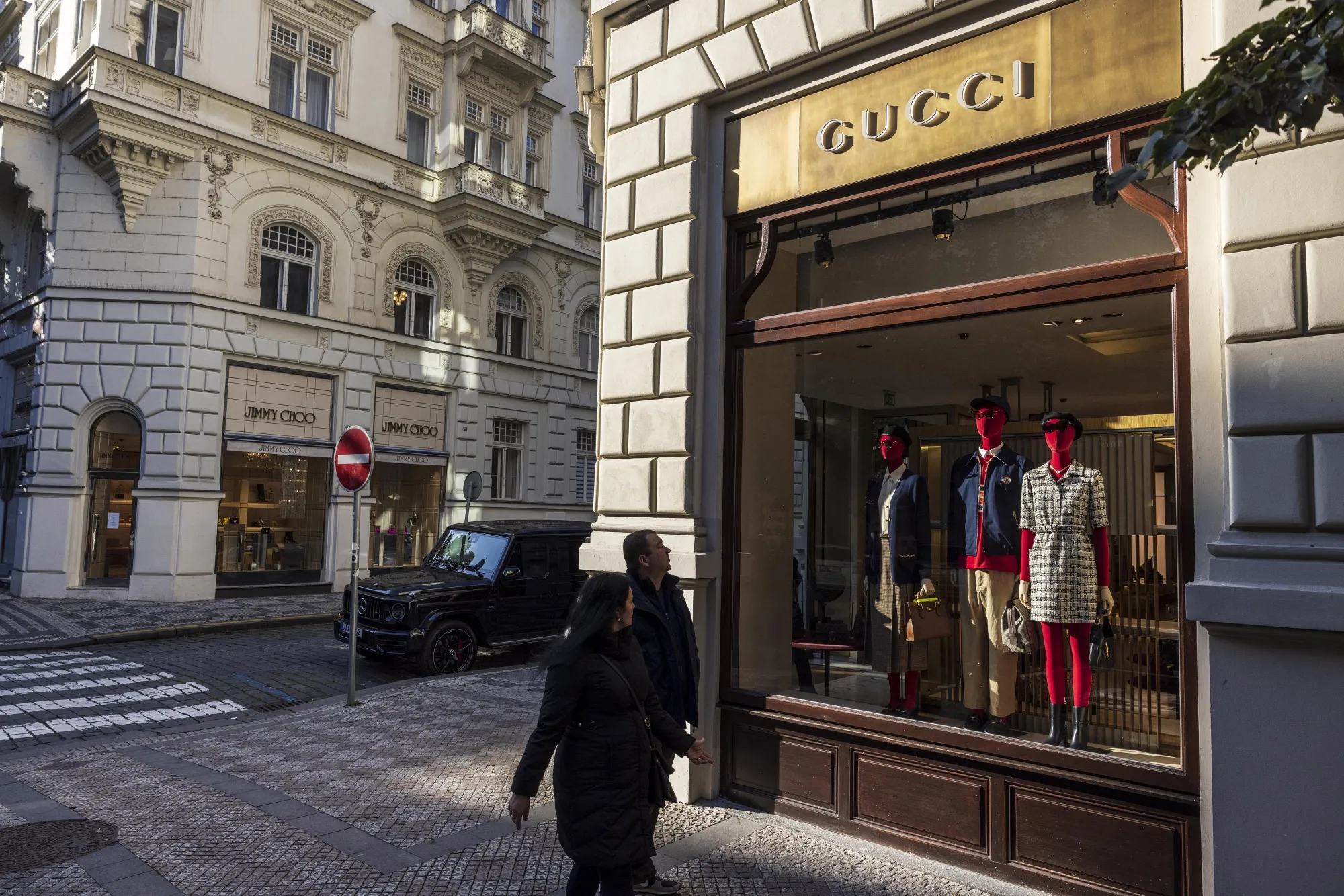 Shoppers pass a Guccio Gucci SpA luxury clothing store in Prague, Czech Republic.