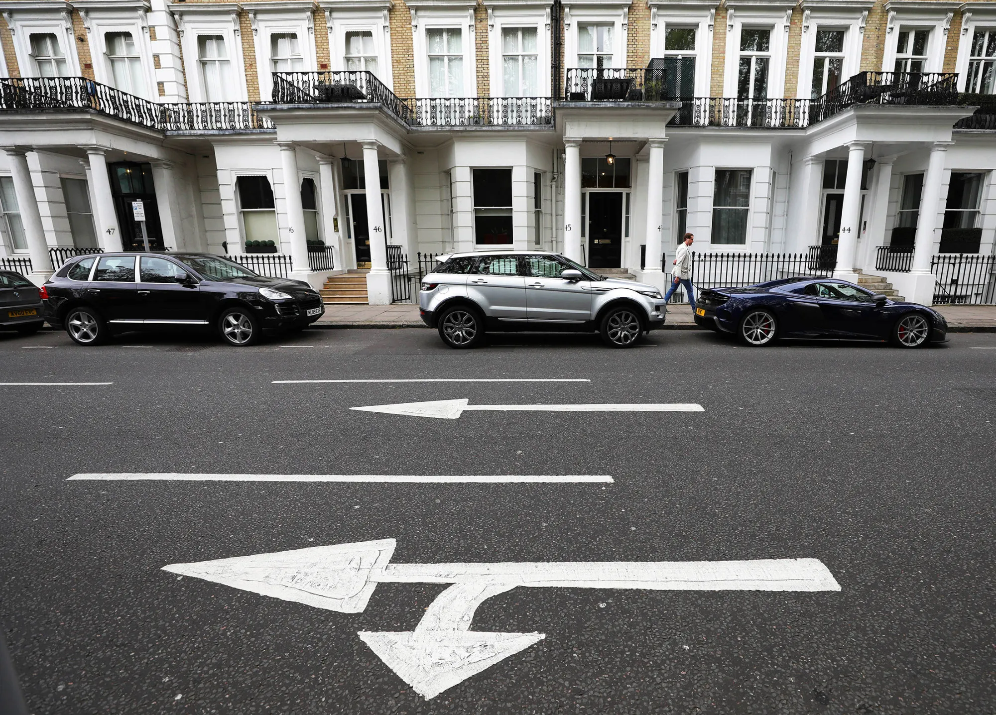 Automobiles stand parked outside a row of residential houses in London, U.K., on Friday, April 21, 2017. Britons' confidence in the housing market stayed near a three-year low in March as sentiment toward the economic outlook soured, according to Halifax.
