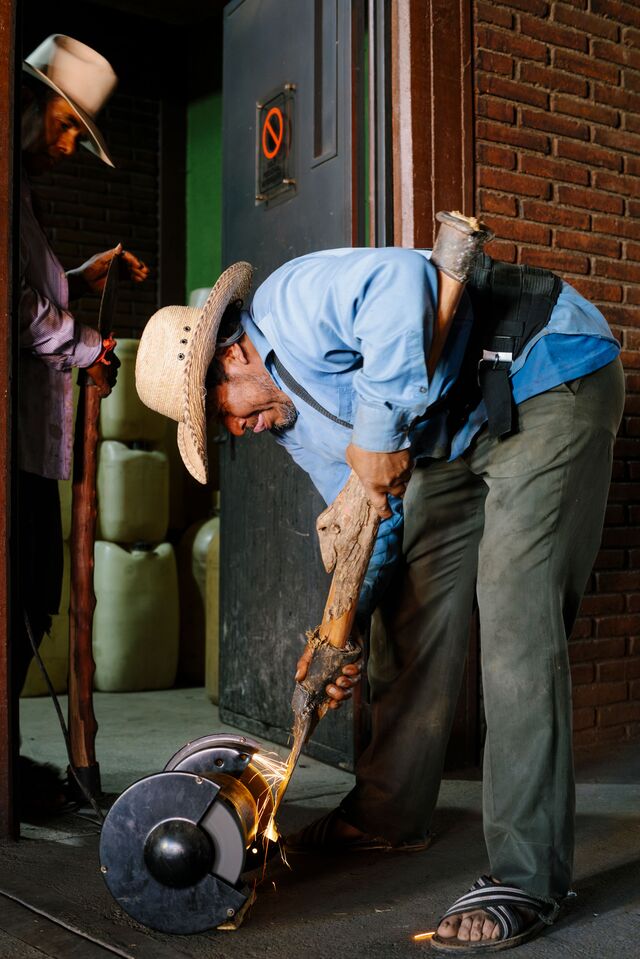 A worker from Real Minero sharpening his coa, a blade used in harvesting.