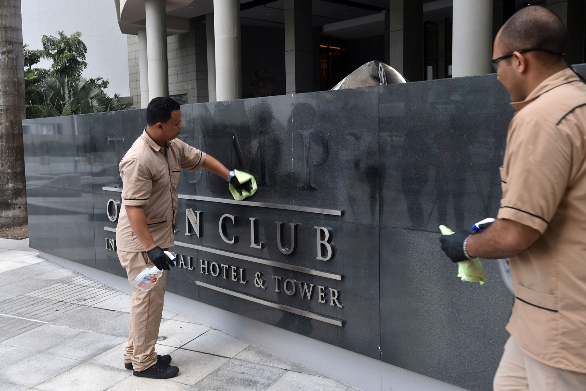 Workers clean a sign after the Trump sign letters were removed, at the Trump Hotel in Panama City on March 5, 2018.&nbsp;