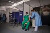 A health care worker administers a Pfizer vaccine to a person wearing medical scrubs inside a pop-up clinic in Bogota, Colombia