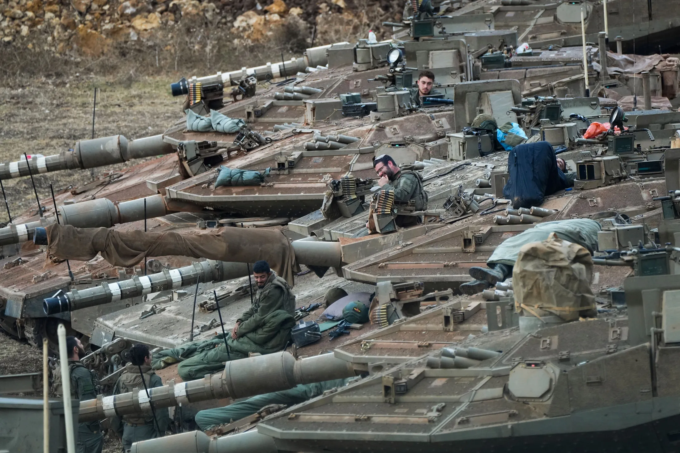 Israeli soldiers work on tanks at a staging area near the border with Lebanon, in northern Israel on Oct. 1.