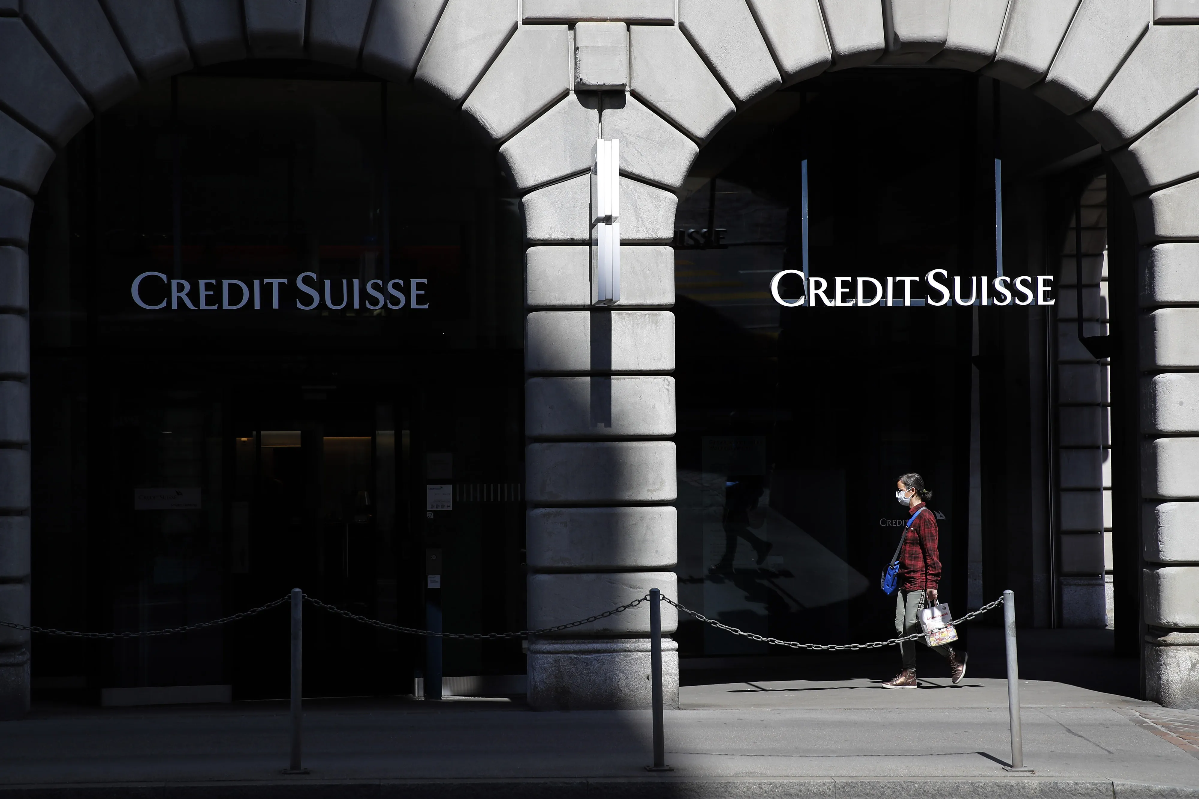 A pedestrian wearing a protective face mask walks past a Credit Suisse Group AG bank branch in Zurich, Switzerland, on Friday, April 17, 2020.&nbsp;