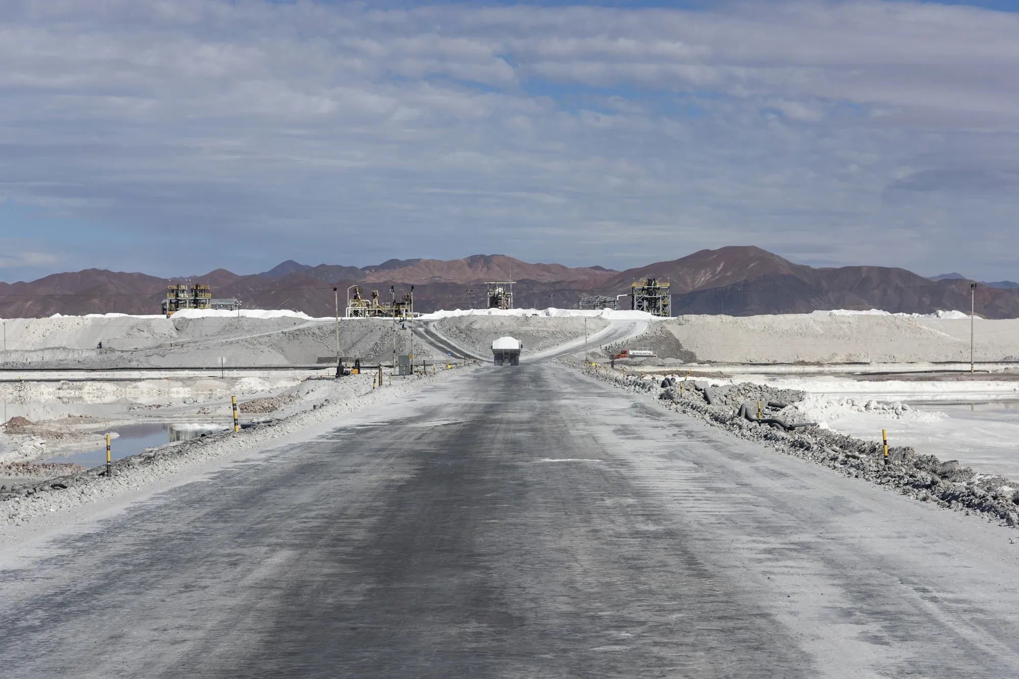 A truck loaded with lithium carbonate travels along a road between brine lakes at a Sociedad Química y Minera de Chile (SQM) lithium mine on the Atacama salt flat in the Atacama Desert, Chile, on May 29, 2019.
