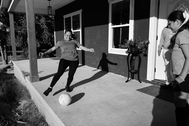 Nunez practices kicking the soccer ball with her daughter Isabelle, 10, on their front porch before she joins for a parent/child scrimmage soccer game.